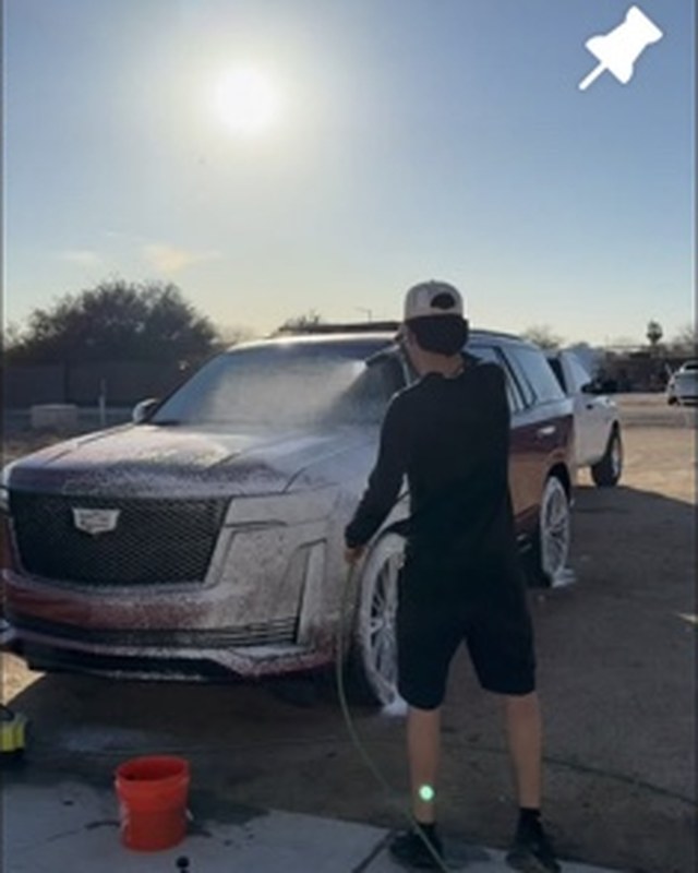 Mobile detailing wash in progress on a Cadillac SUV